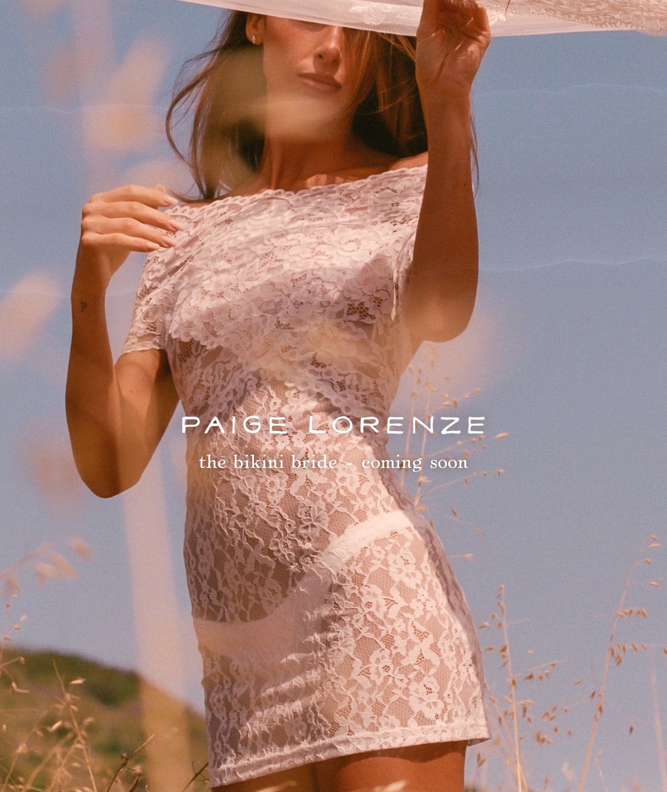 Woman holding a sheer fabric over her face with 'Paige Lorenze' branding in a field.